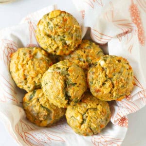 A napkin lined basket of feta spinach muffins.