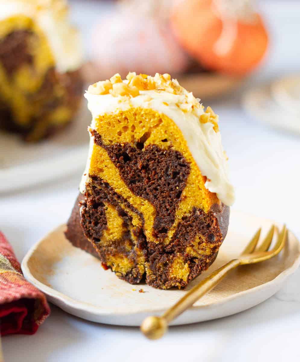 Slice of Pumpkin Swirl Cake with Cream Cheese Frosting on a small plate