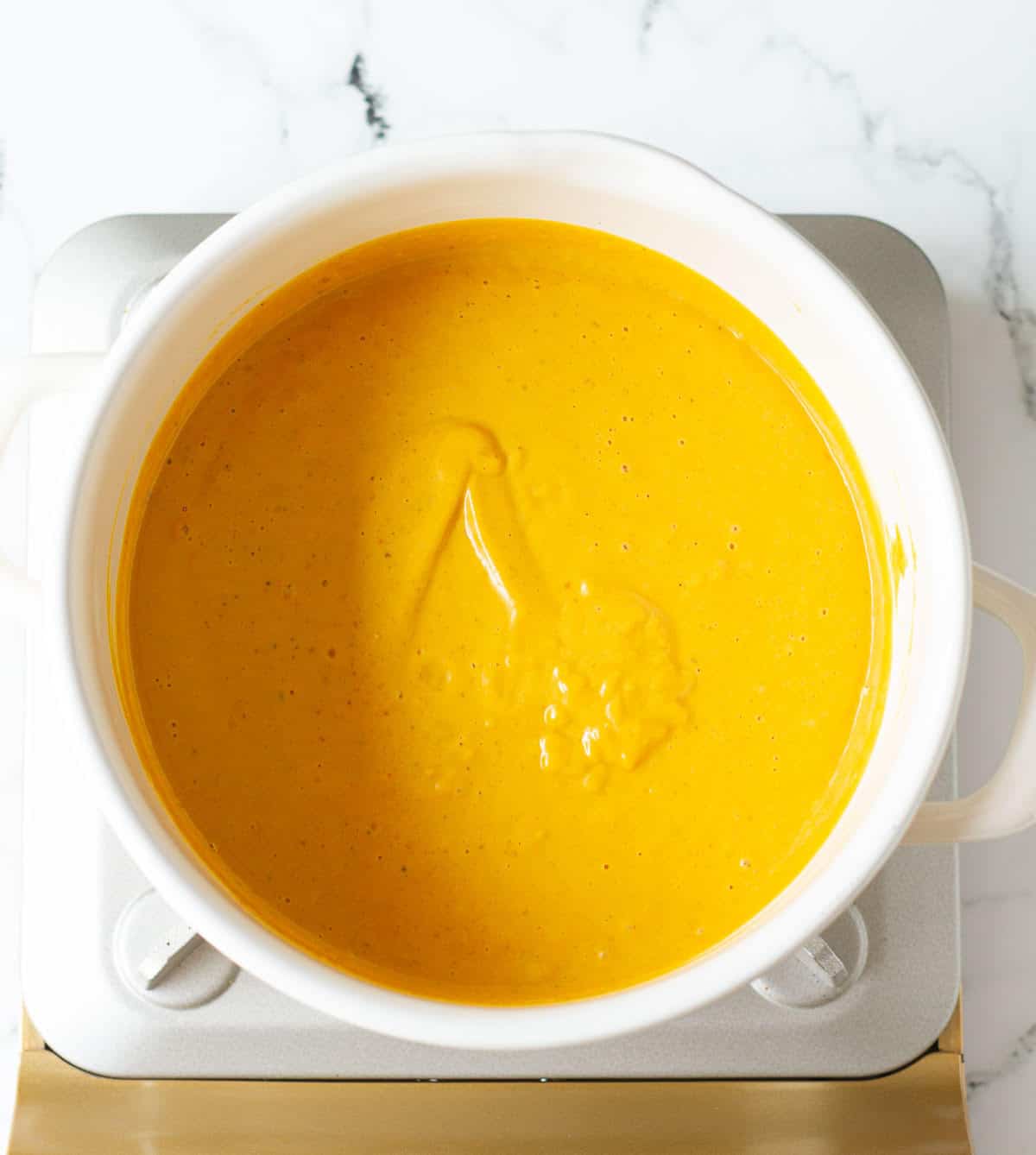 Pumpkin sauce in a white stock pot.