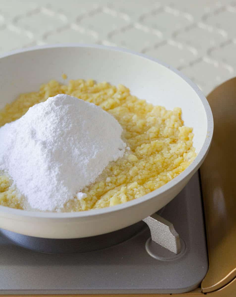 sugar cooking with khoya in a pan