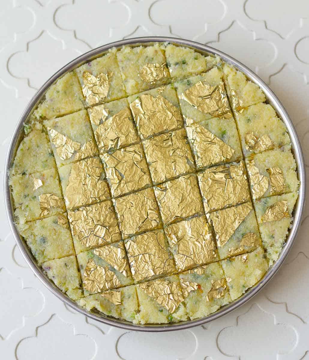 coconut burfi decorated with gold foil and cut into pieces