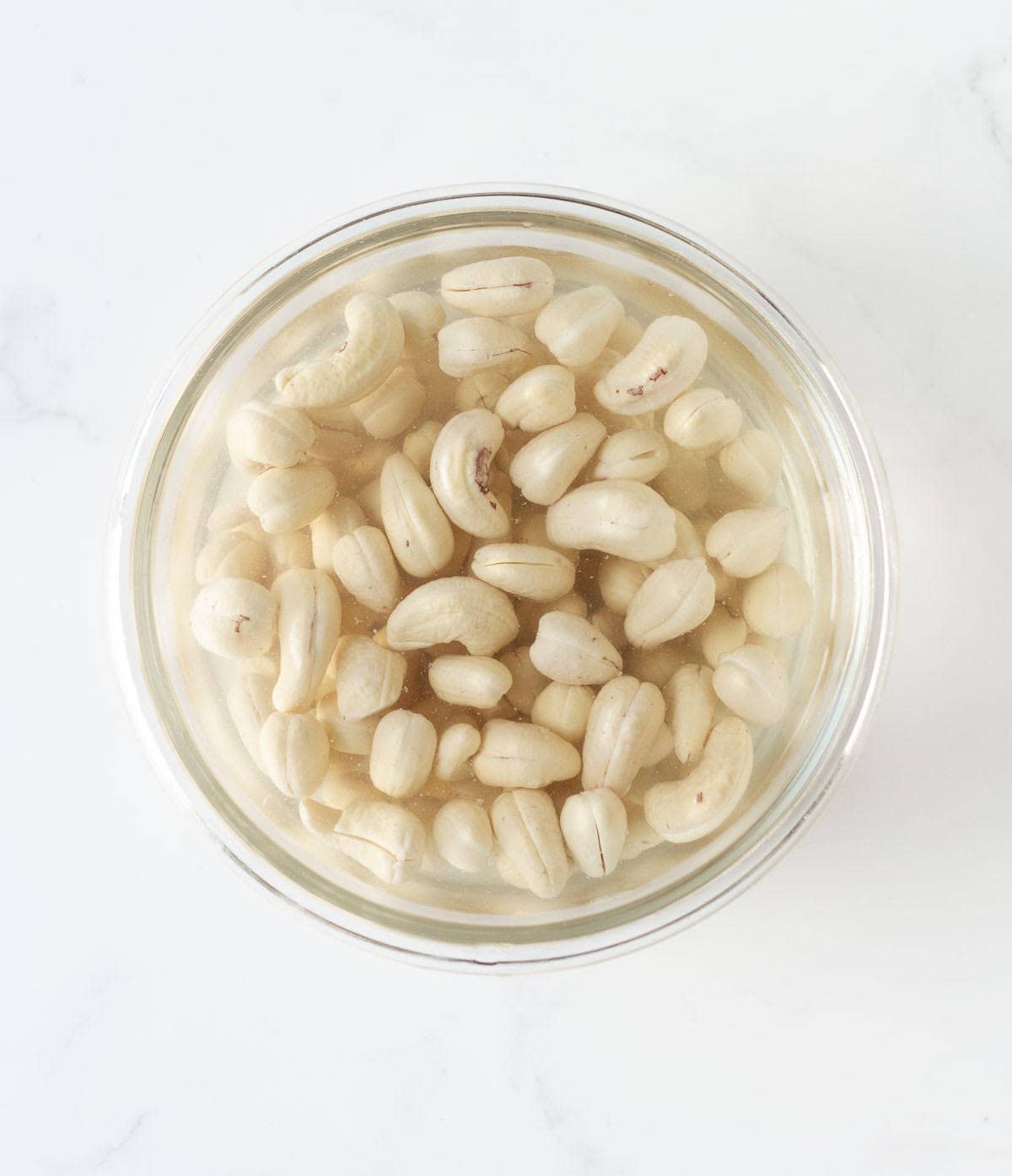 cashews soaked in water in a bowl.