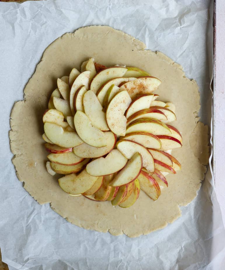 Rolled out pastry dough with marzipan and apples slices on top for Apple Marzipan Galette | Easy gluten-free apple galette with homemade marzipanApple Marzipan Galette | Easy gluten-free apple galette with homemade marzipan
