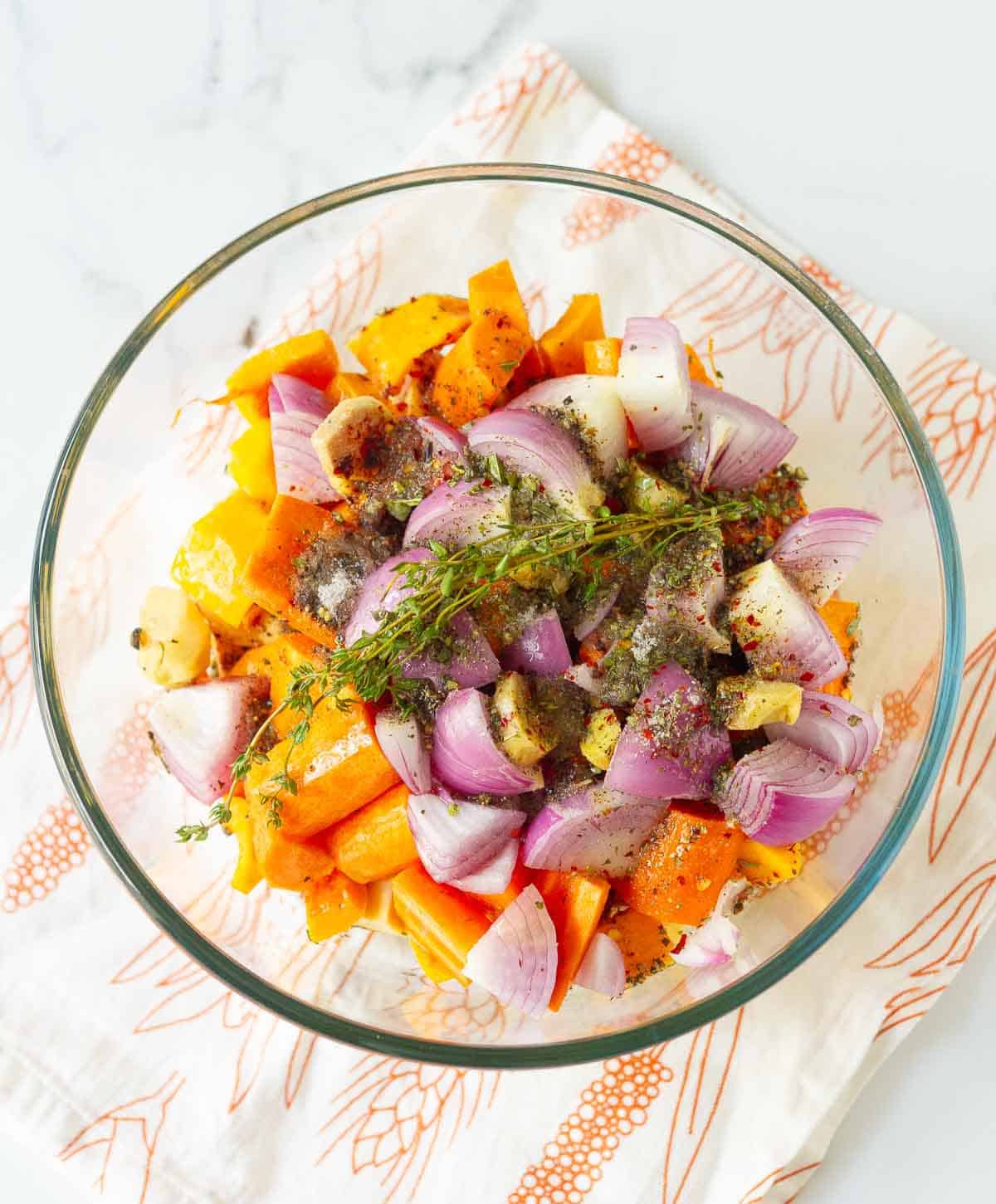 chopped vegetables for making the soup in a mixing bowl with olive and spices.