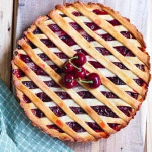 Cherry pie with a few fresh cherries on top.