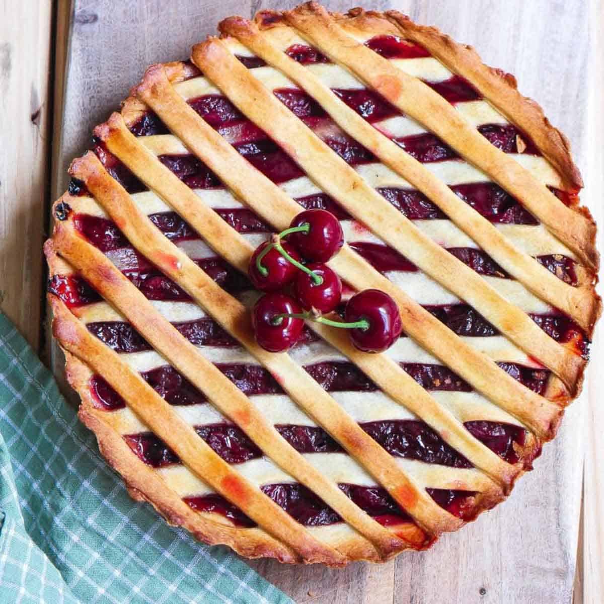 Cherry pie with a few fresh cherries on top.