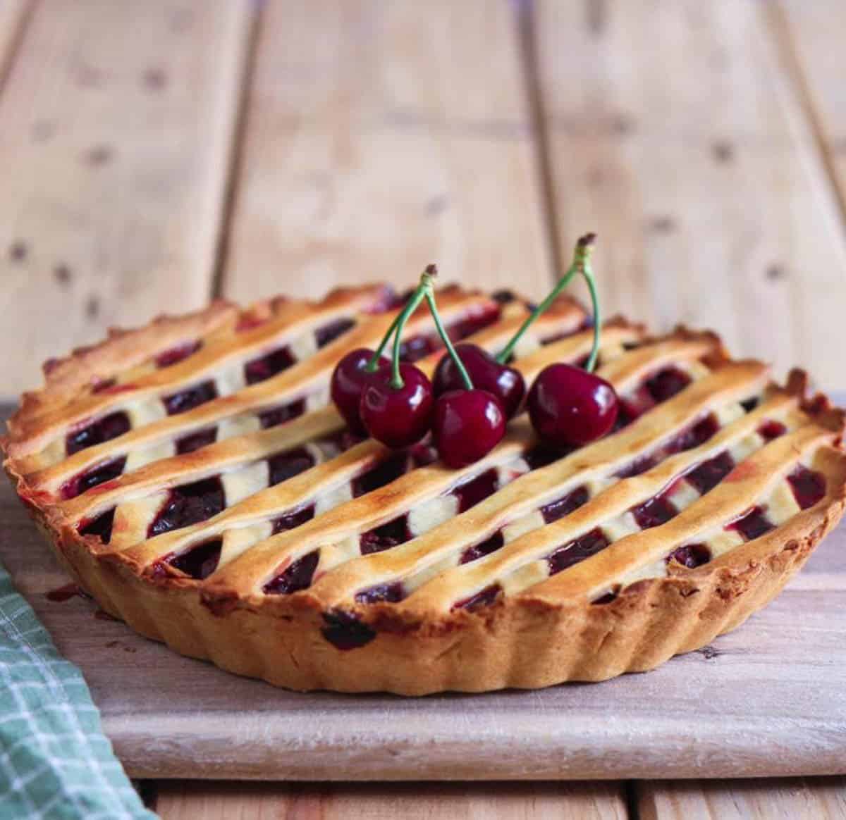 Cherry pie on a wooden board.
