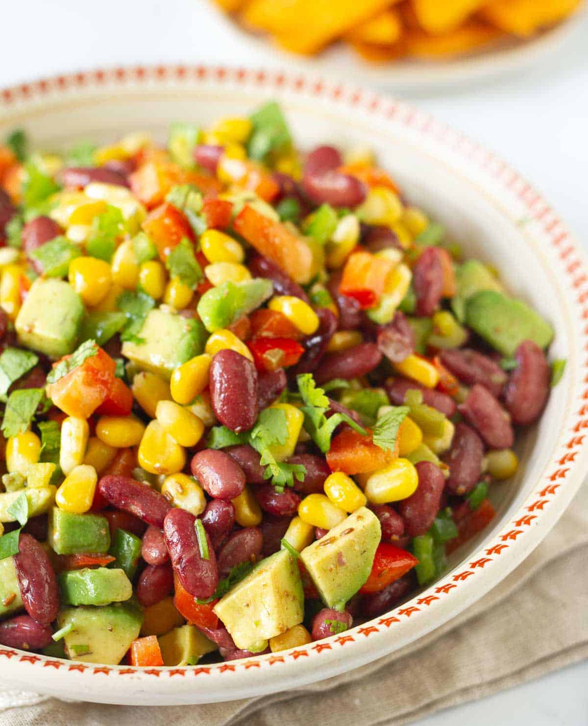 A bowl of corn bean and avocado salad.