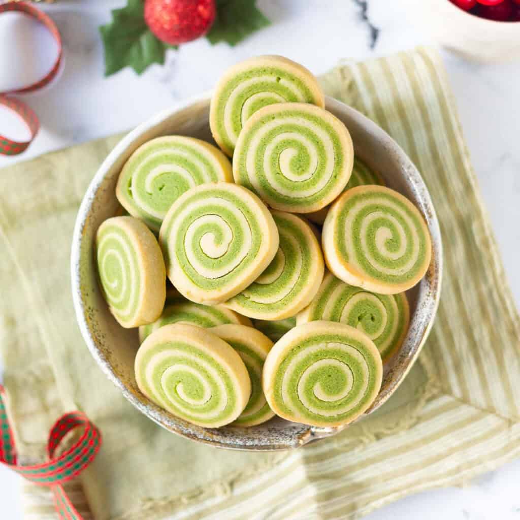 matcha pinwheel cookies in a bowl on a green napkin.