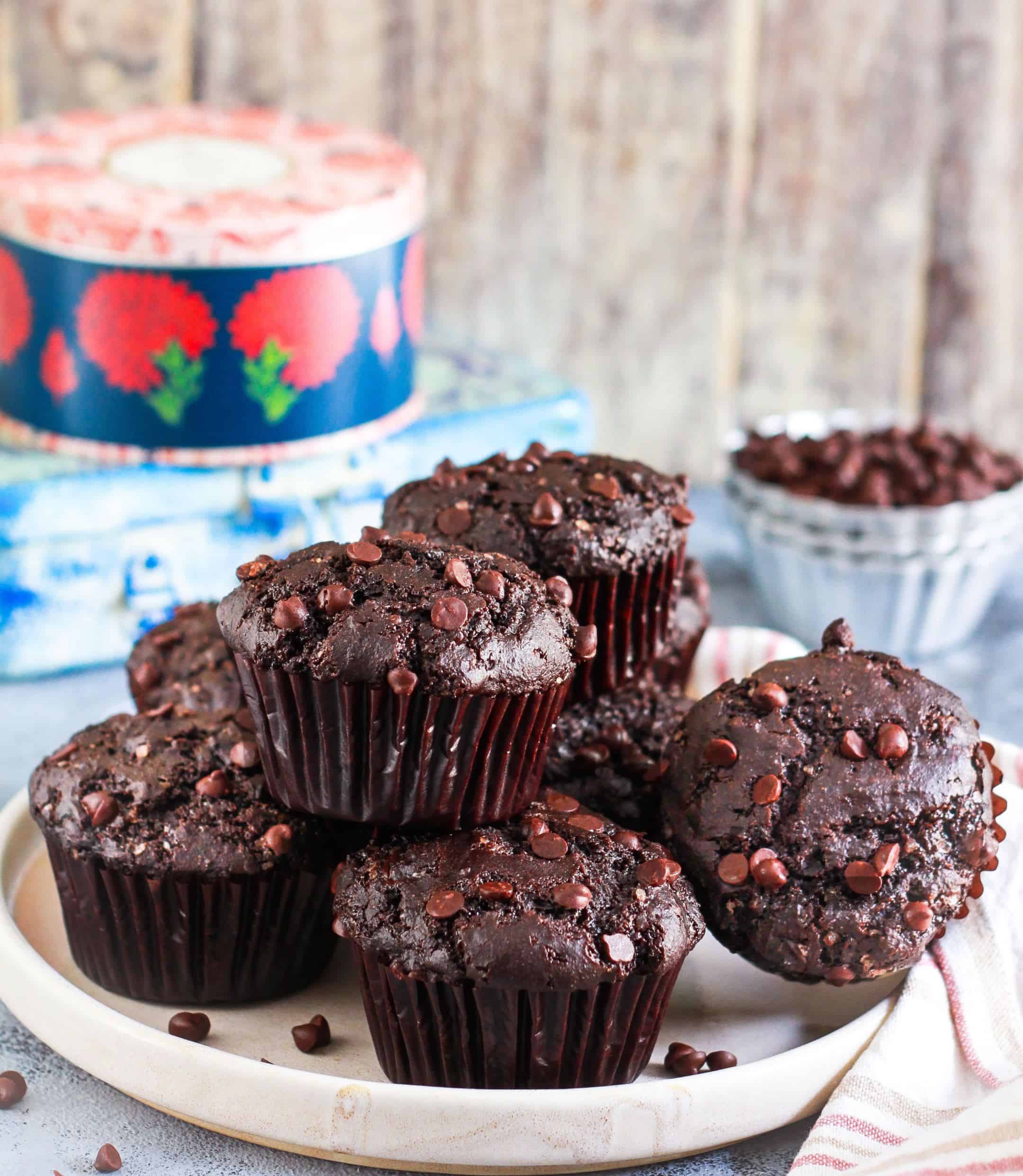 Eggless Chocolate Protein Muffins on a plate with ingredients in the background.