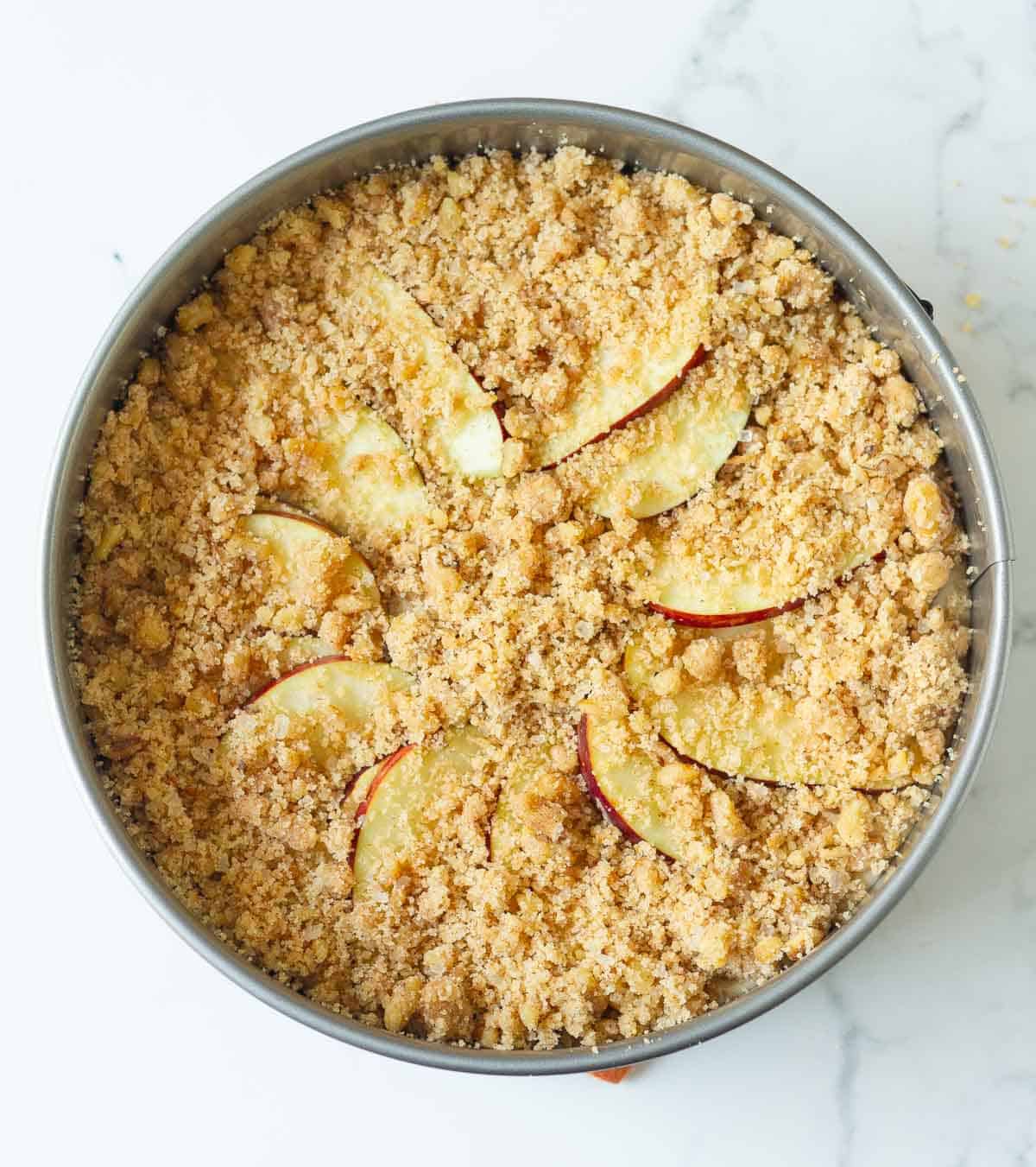 Streusel on top of cake batter in a cake tin.