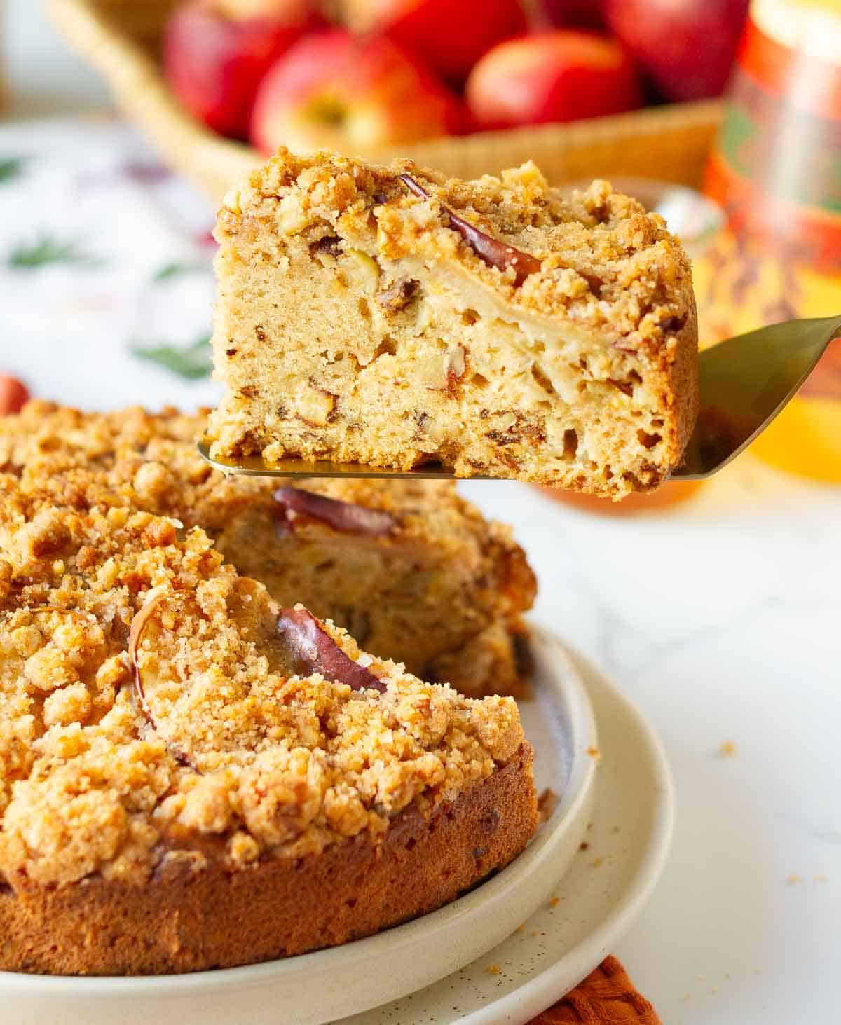 A slice of apple cake on a cake server.