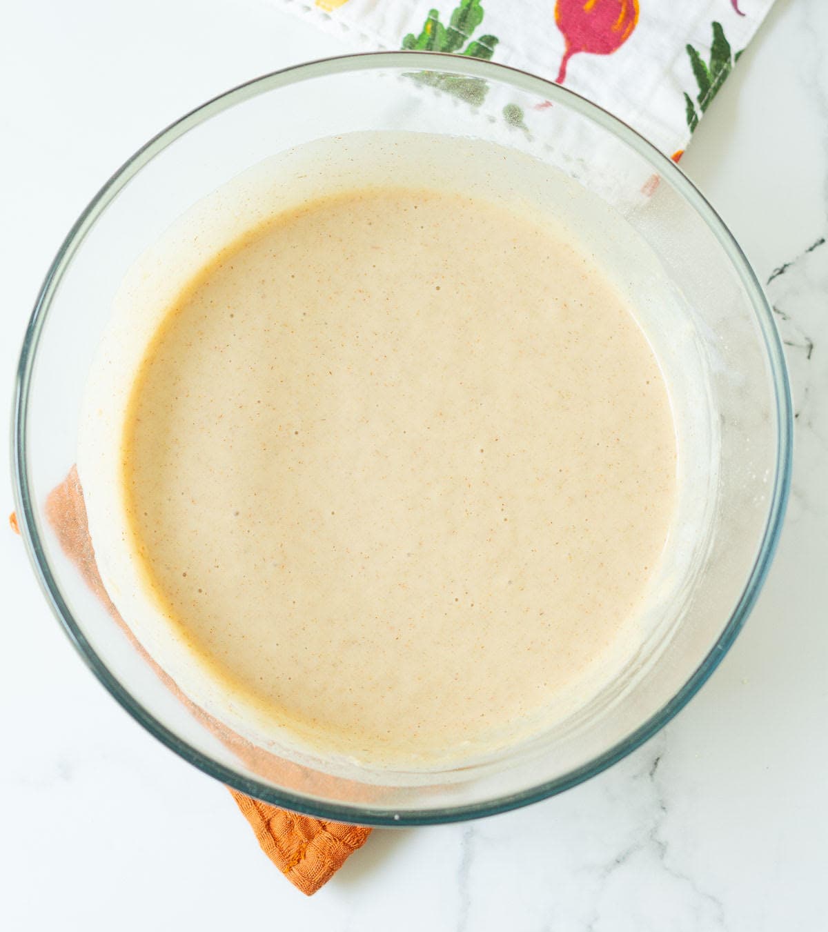 Batter for making apple cake in a mixing bowl.