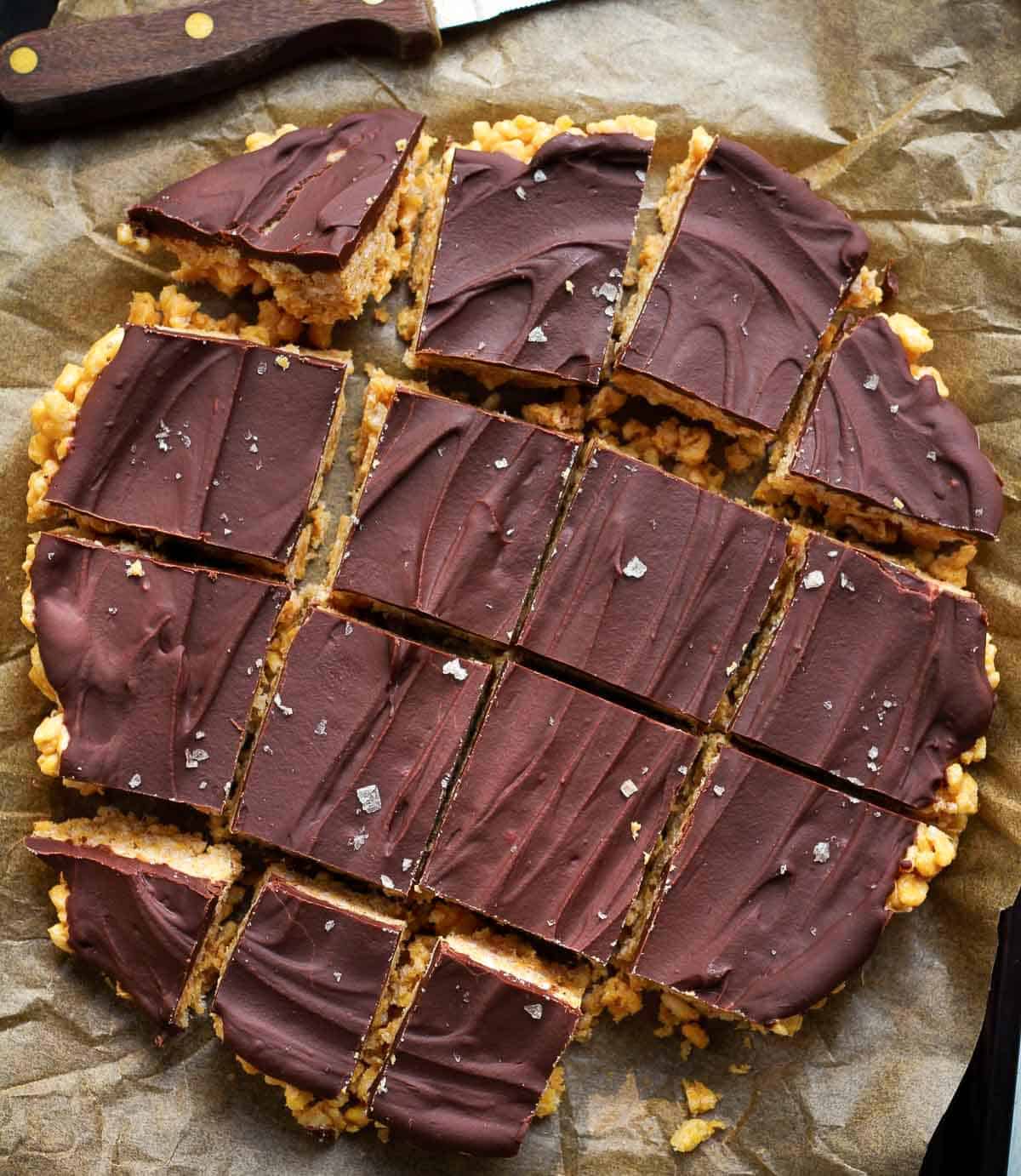 Chocolate coated Rice Krispie treats cut into 16 squares.