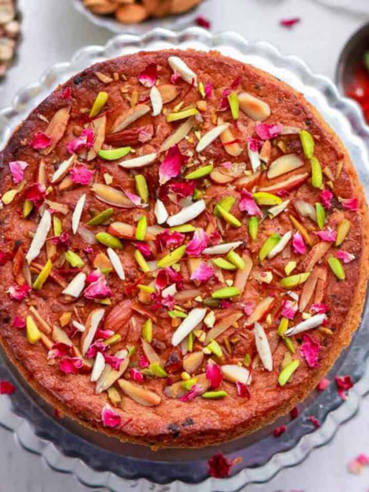 Mawa cake with almonds and pistachios on a cake platter.