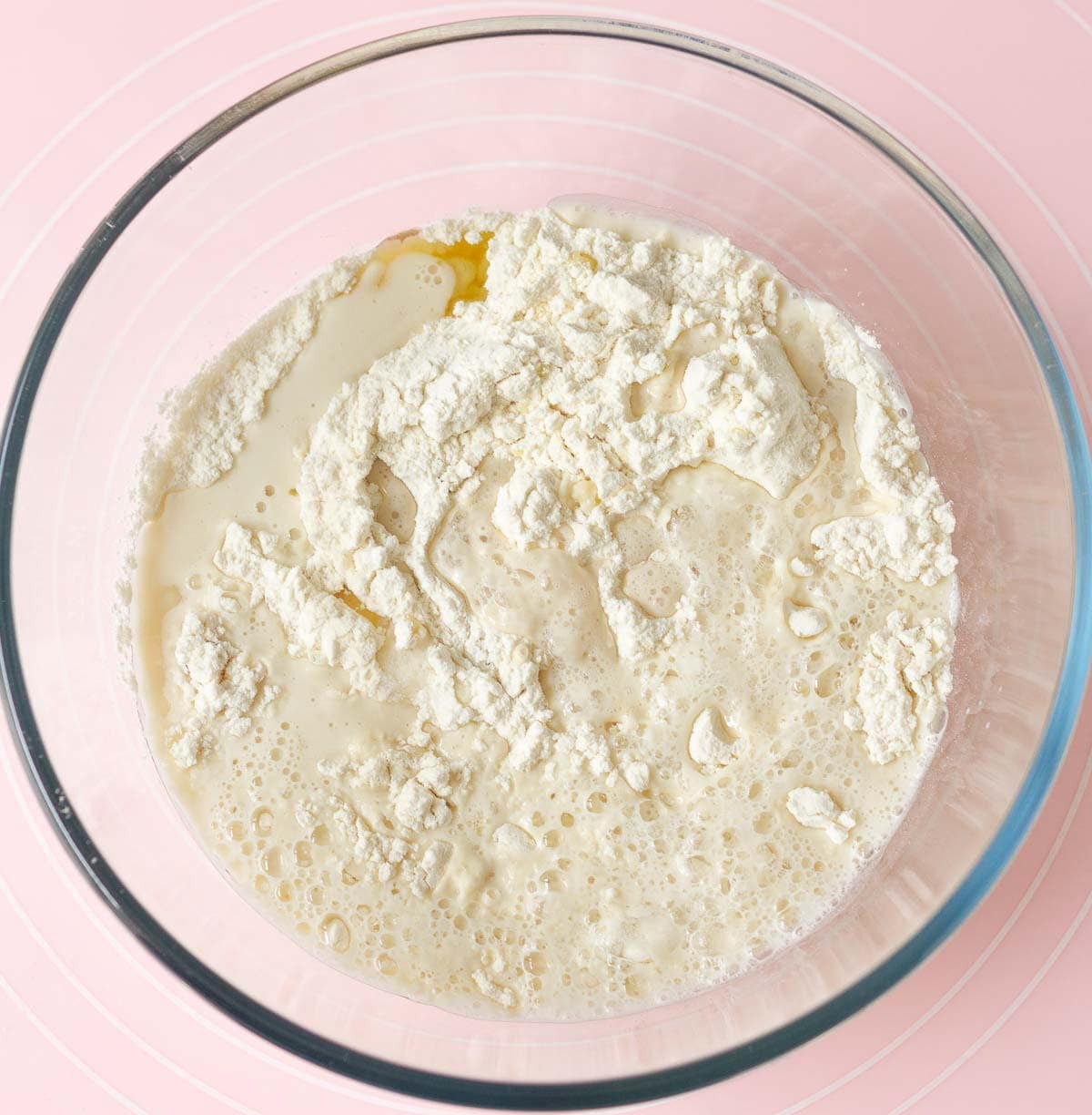 Yeast mixture in a mixing bowl with flour.