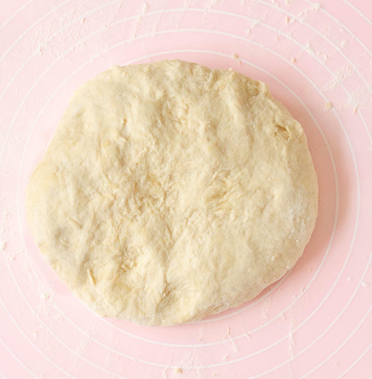 Bread dough on a pink silicone sheet.