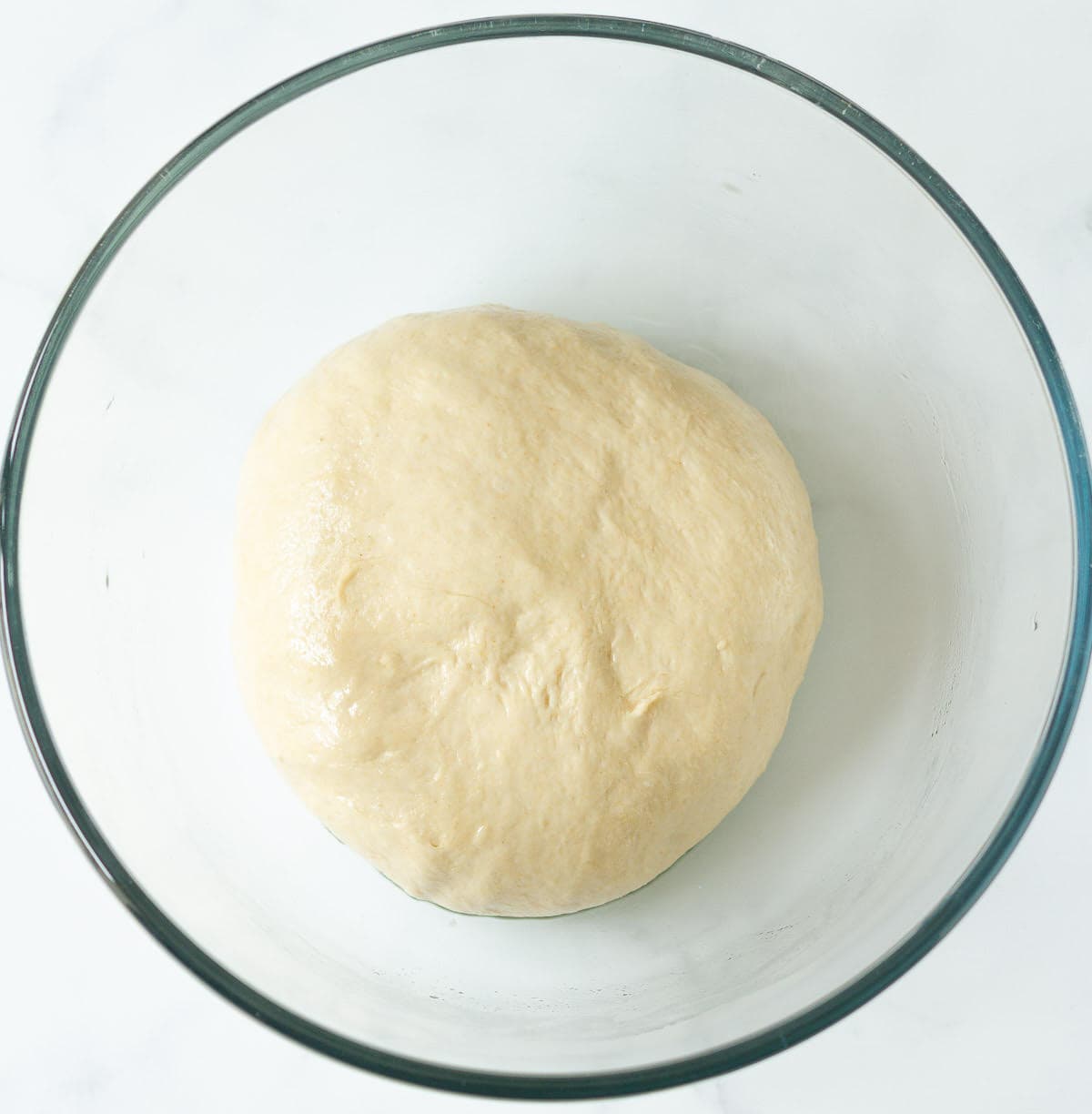 Kneaded bread dough in a mixing bowl.