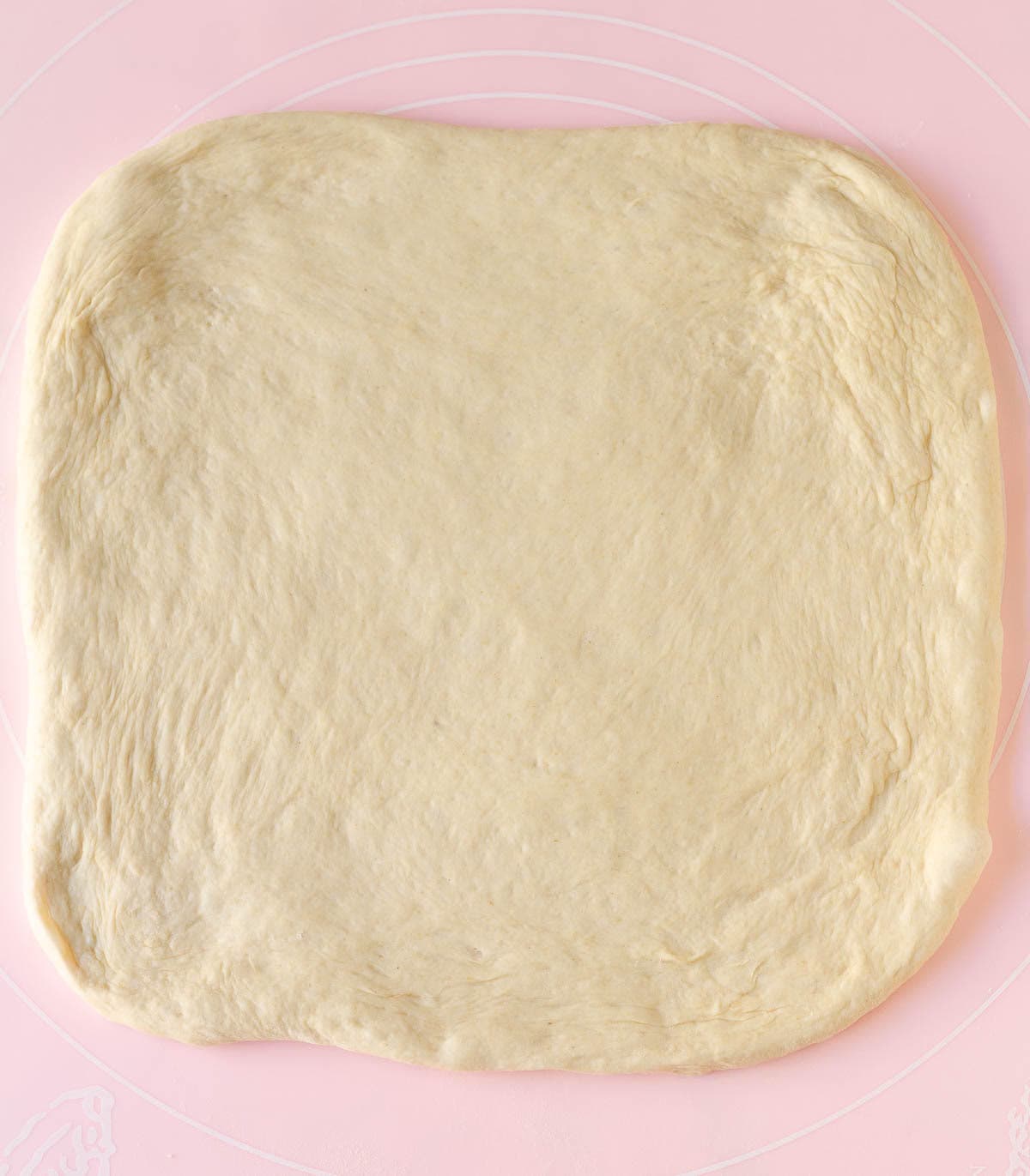 Rolled out dough on a silicone sheet.