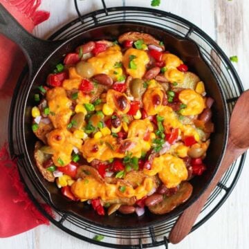 Loaded Potato Nachos in a cast iron skillet.