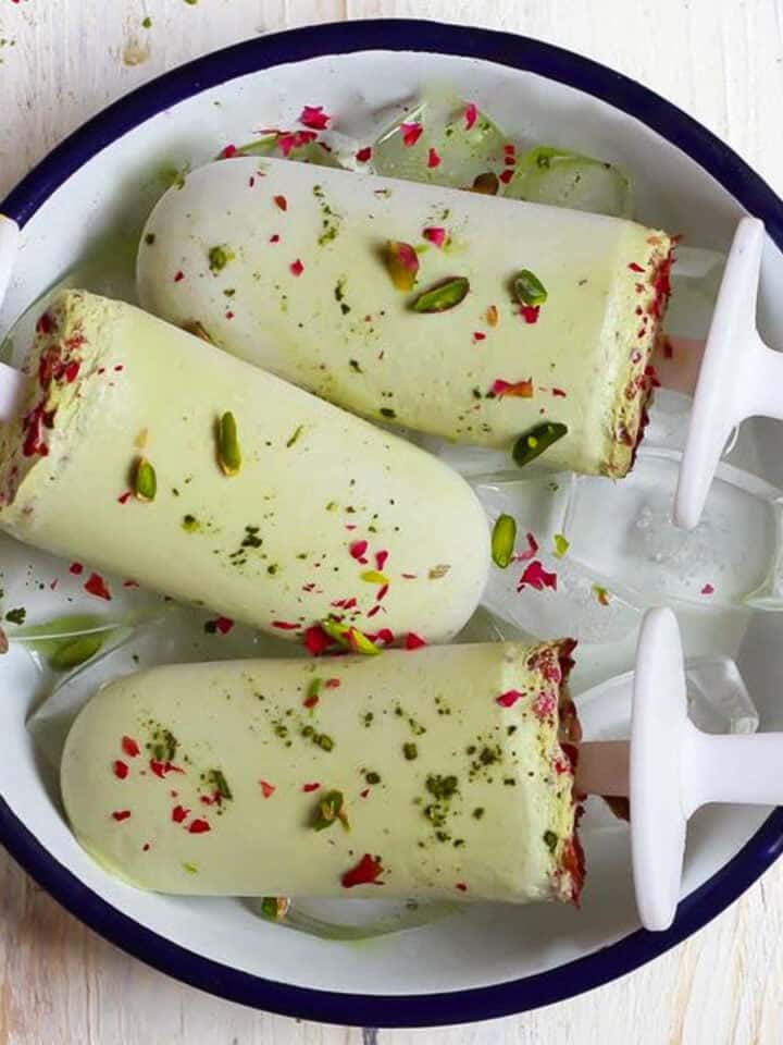 3 pistachio matcha popsicles in a small tray.