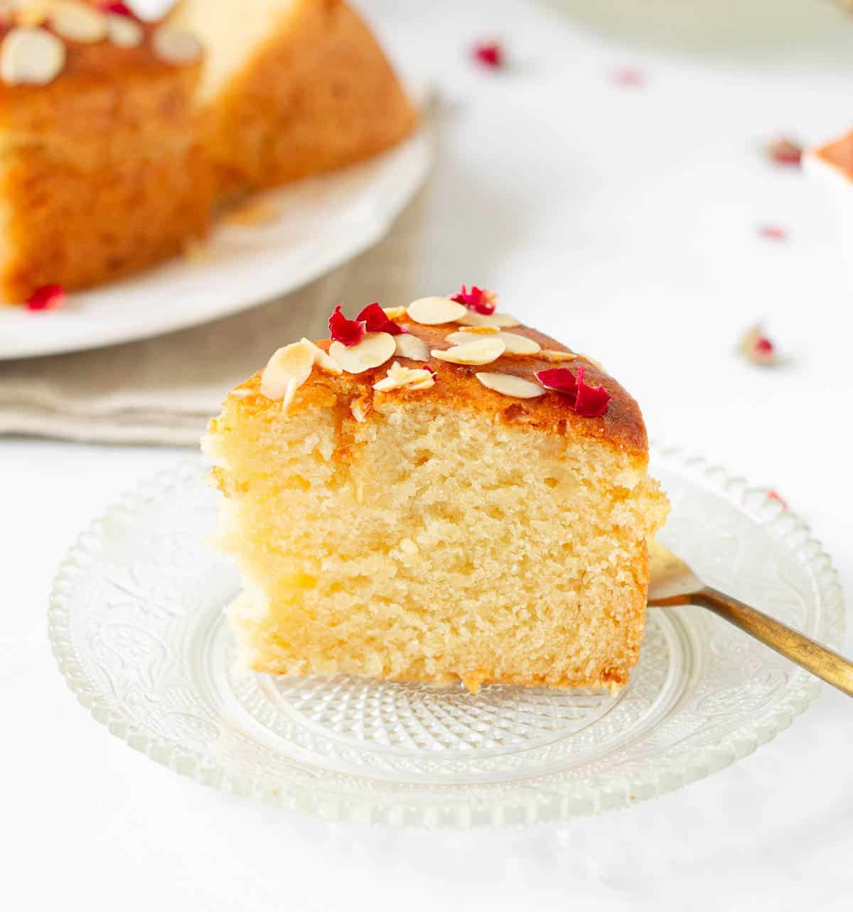 A slice of cake on a small glass plate with a fork.
