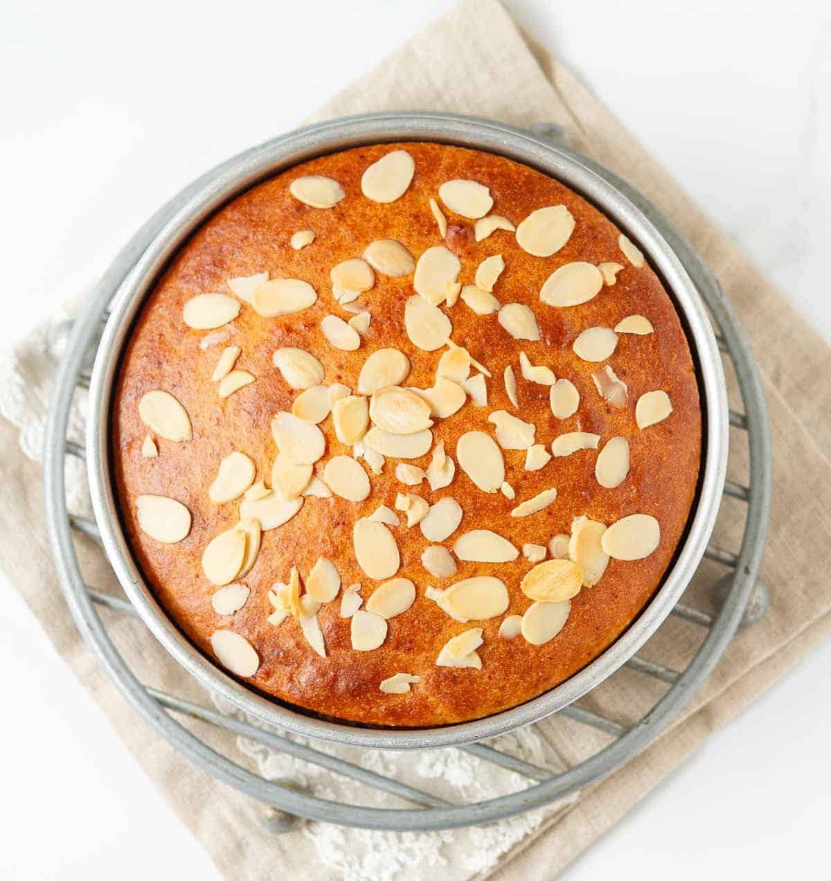 Baked almond cake in a cake pan.