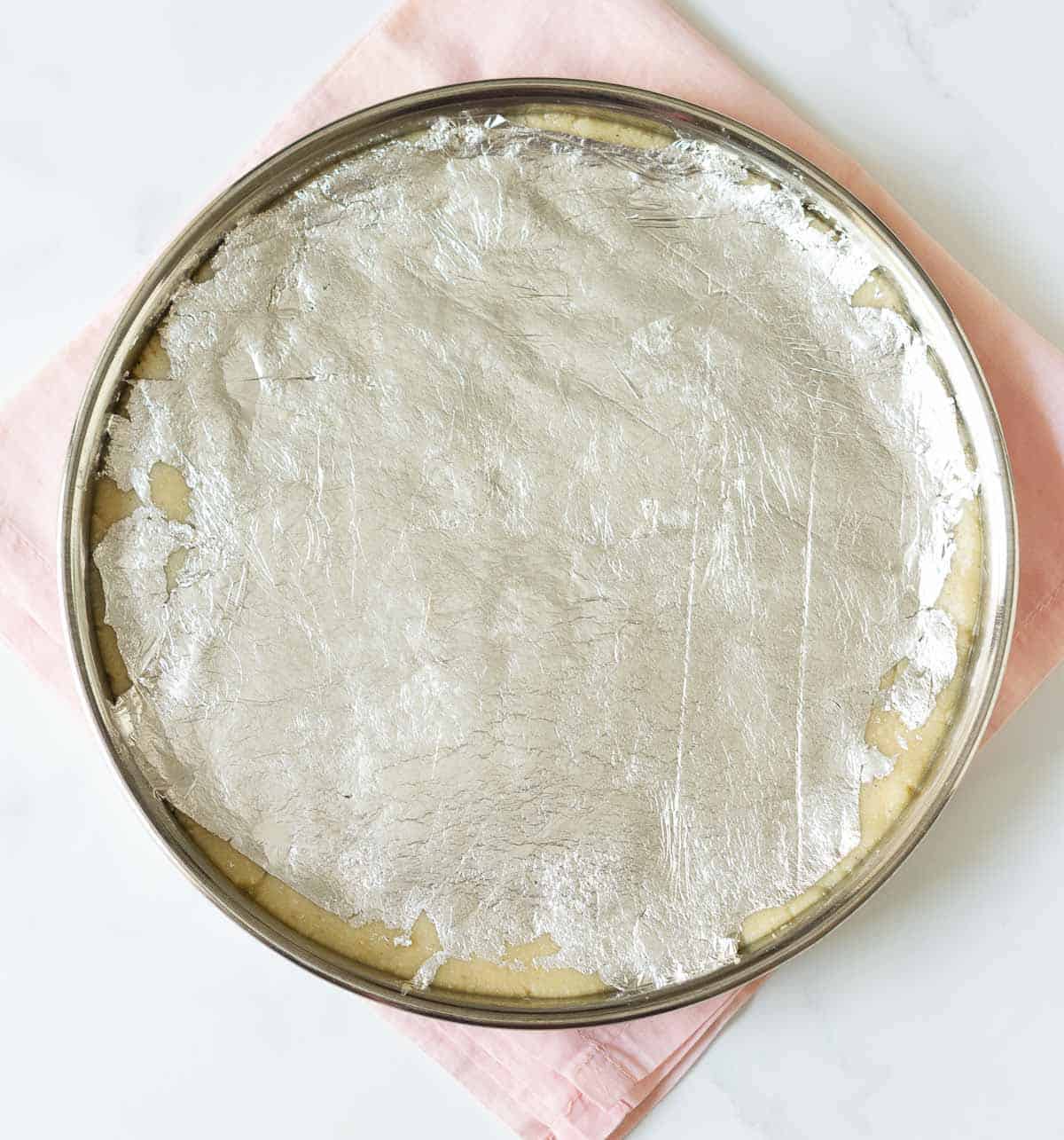 Kaju katli dough covered with silver foil.