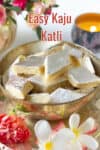 Kaju burfi in a bowl with flowers and candle in the background.