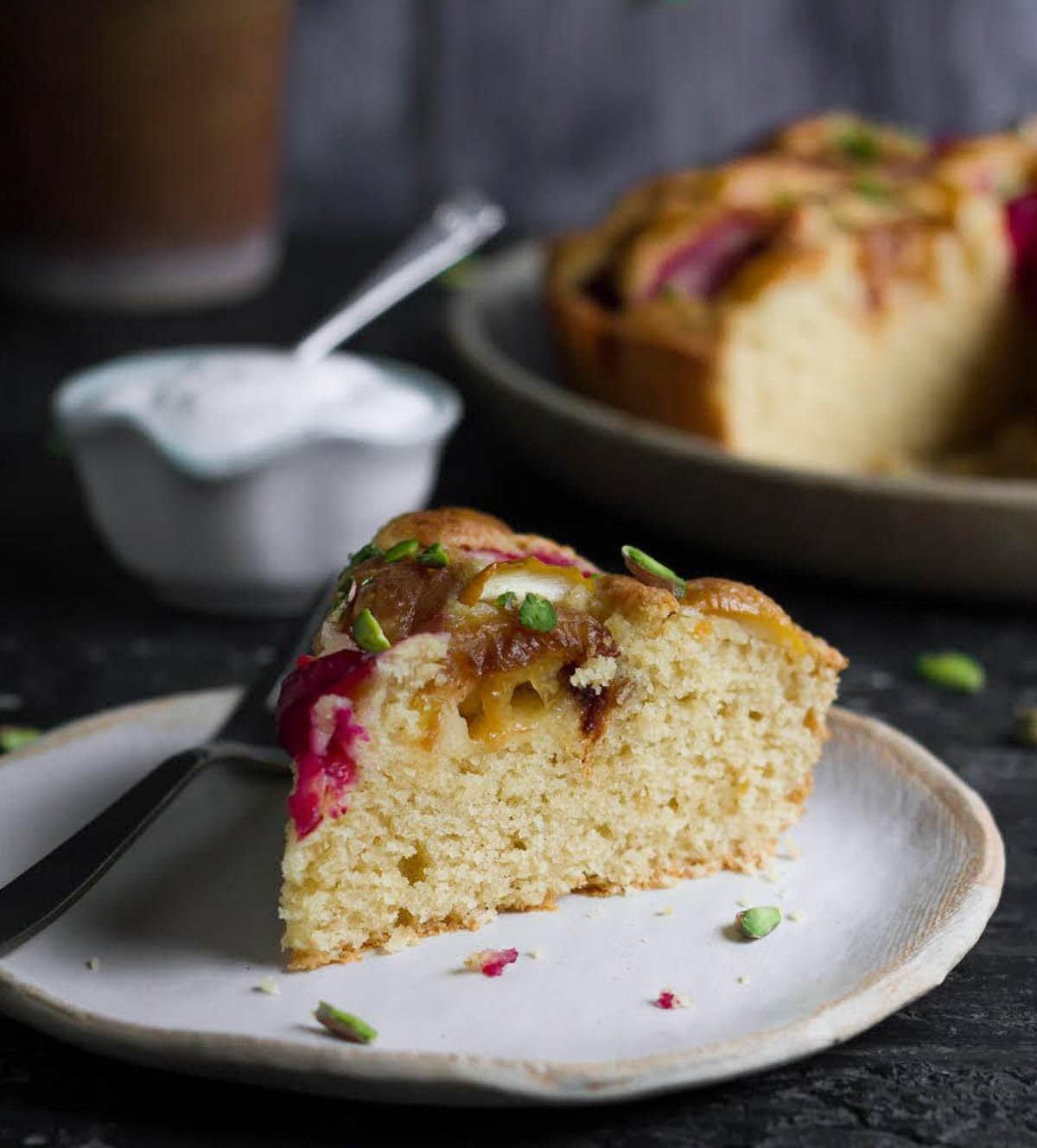 A slice of cake with a bowl of whipped cream.