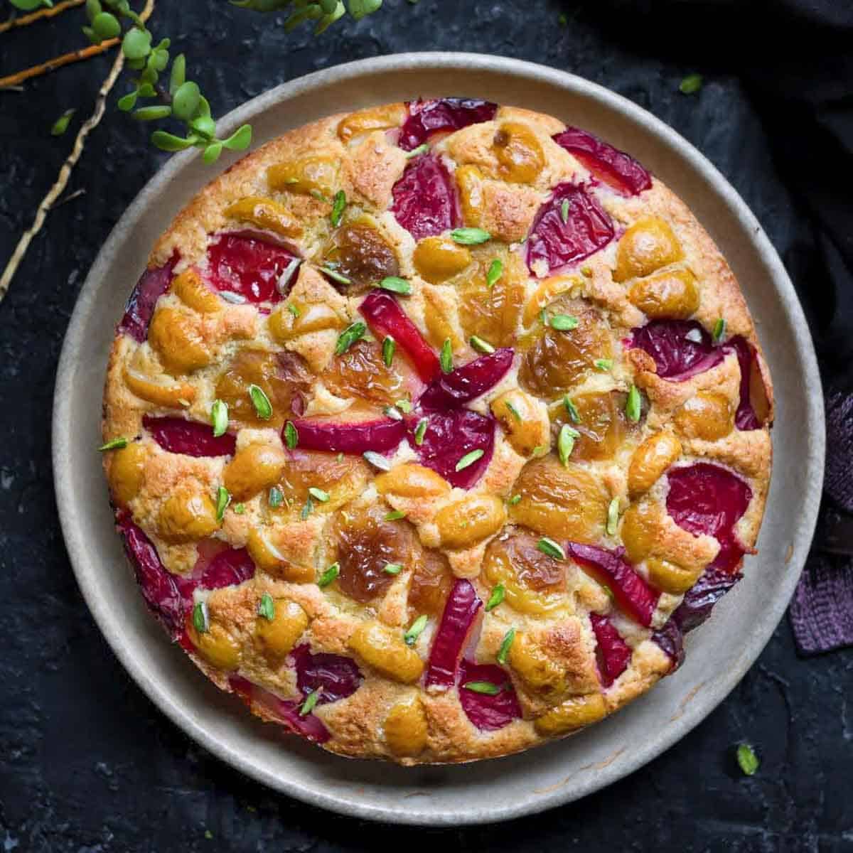 cake with plums and apricots on a platter.