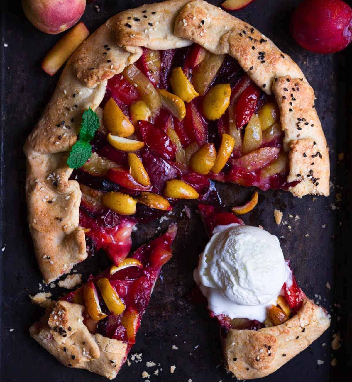 A galette with fruits and a scoop of ice cream on one piece.