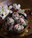 A bowl with chocolate pedas with white flowers around.
