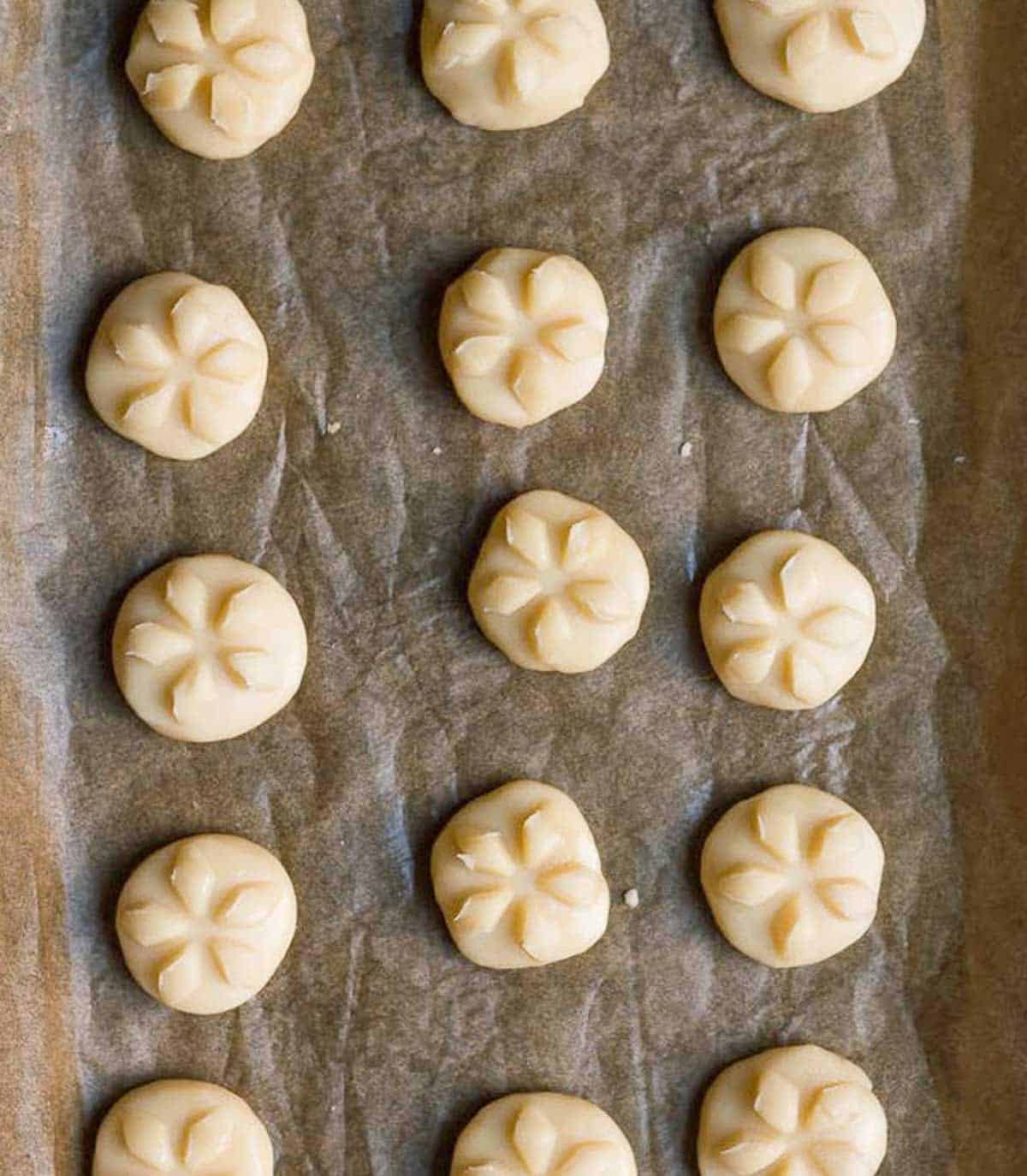 Cookie dough with design on top on parchment paper.