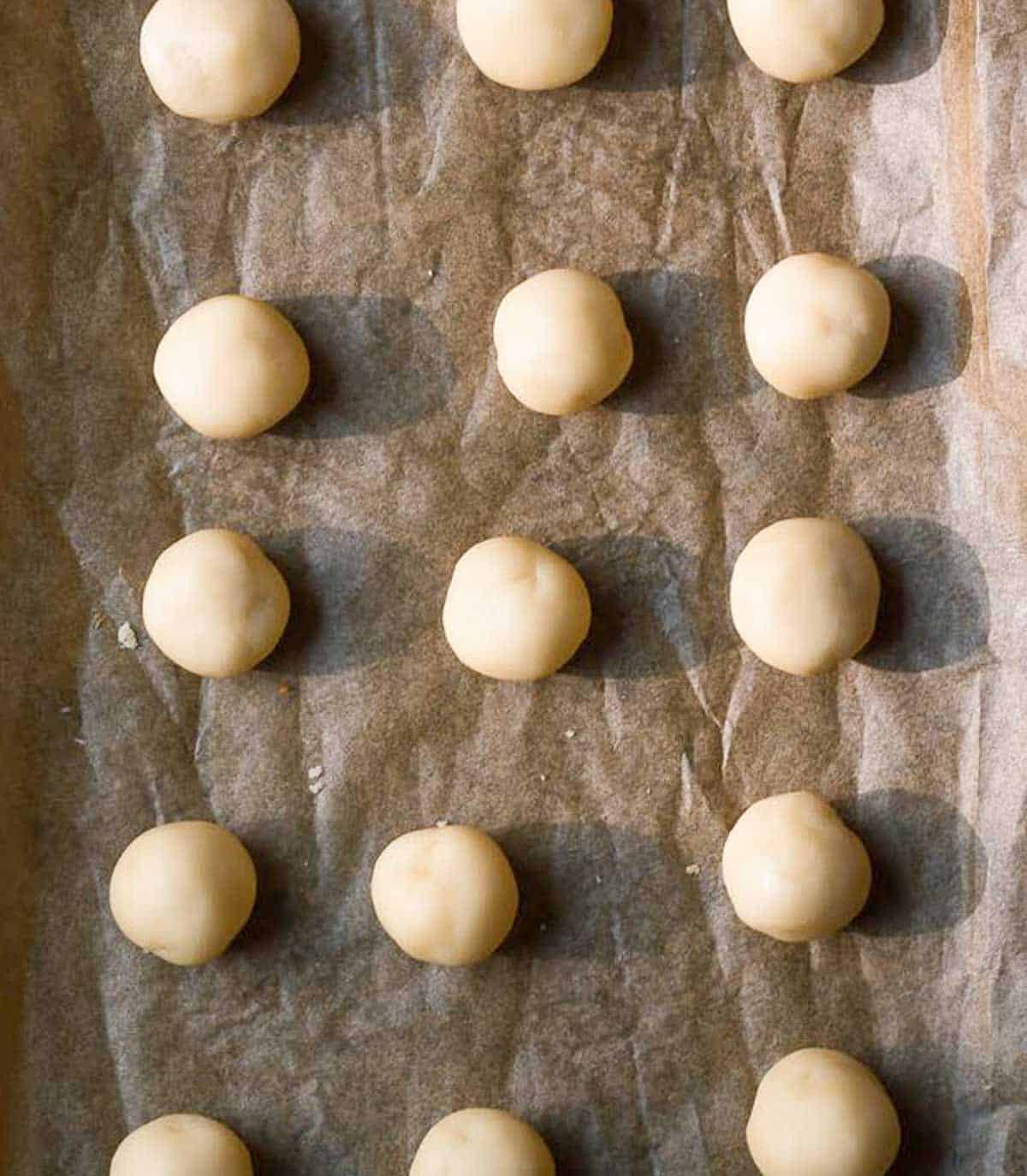 Cookie dough balls on parchment paper.