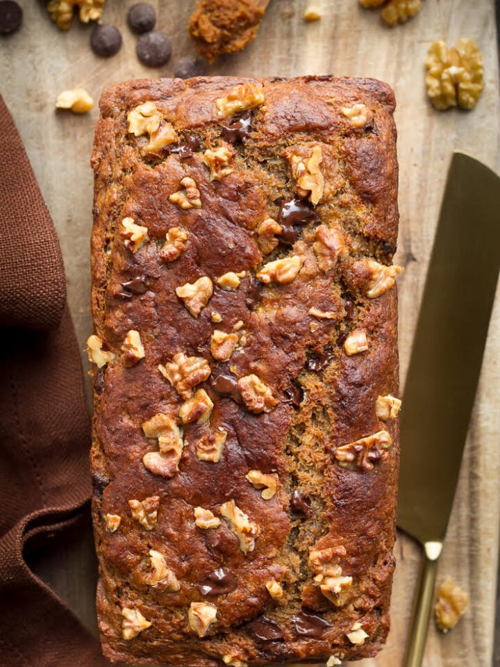 Miso banana bread on a wooden board with a knife.