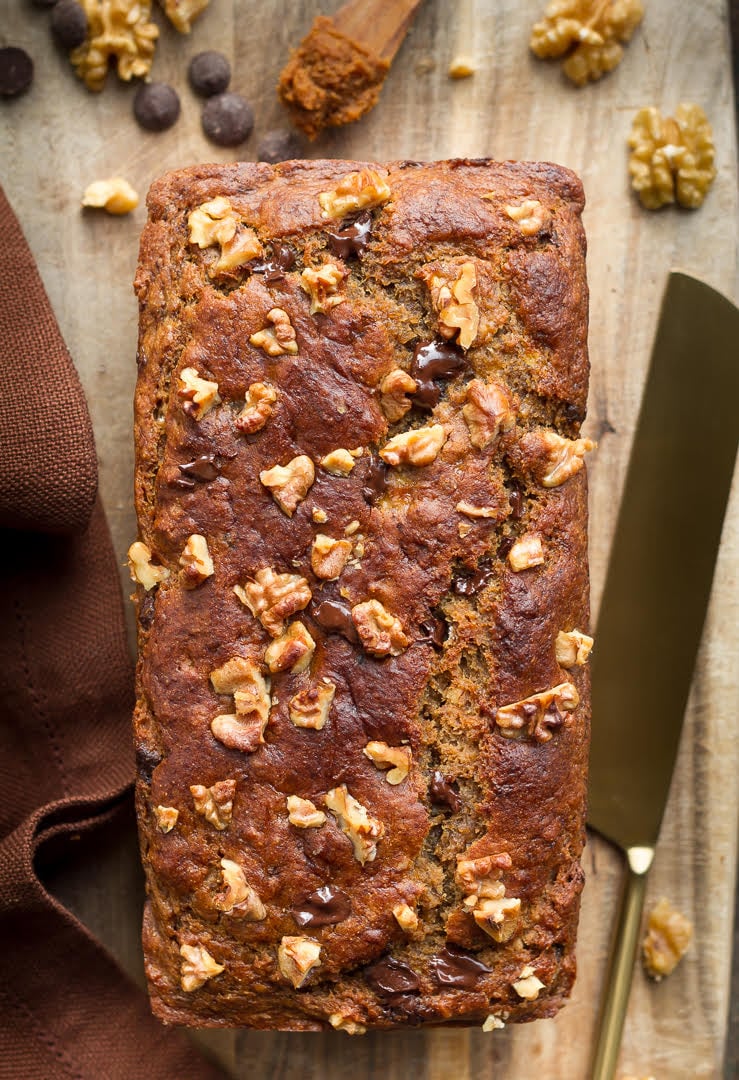Miso banana bread on a wooden board with a knife.
