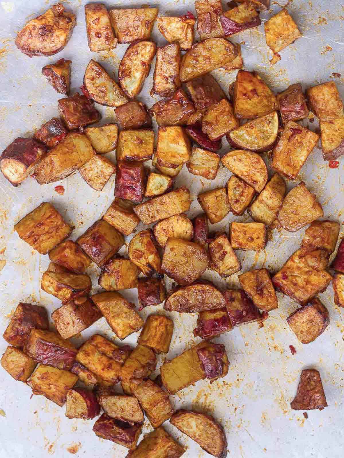 Glazed sweet potatoes on a baking tray.