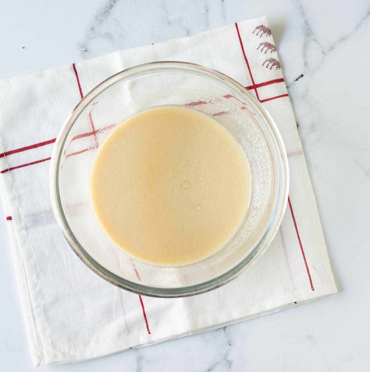 A mixture of oil, milk, and vanilla extract in a bowl.