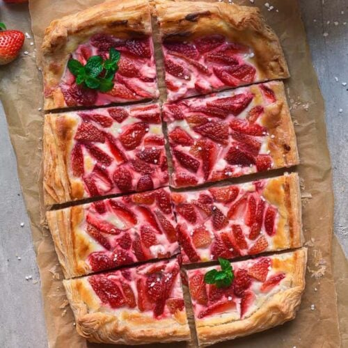 Strawberry Puff Pastry Tart cut into pieces on a parchment paper.