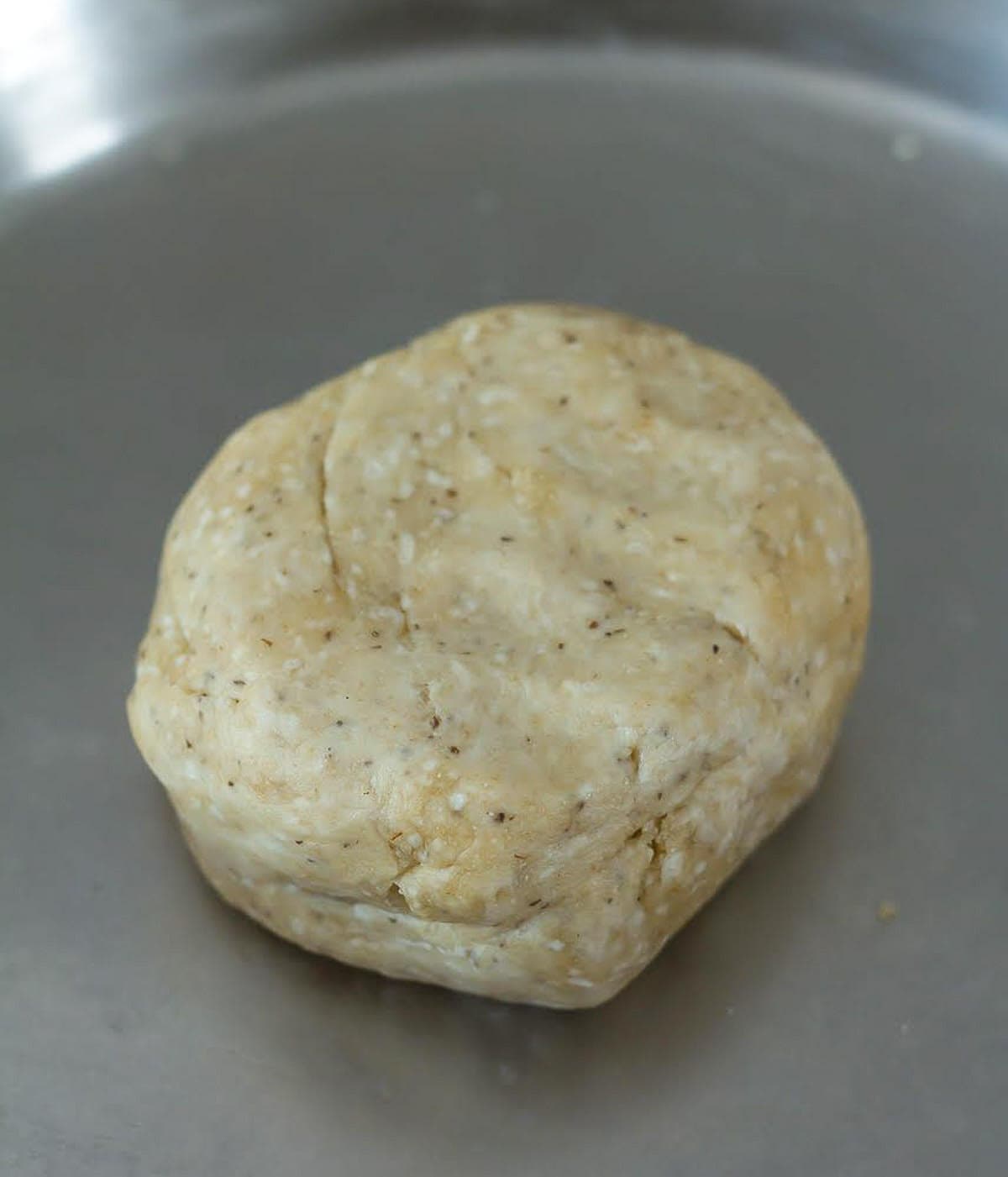 A dough on a stainless steel plate.