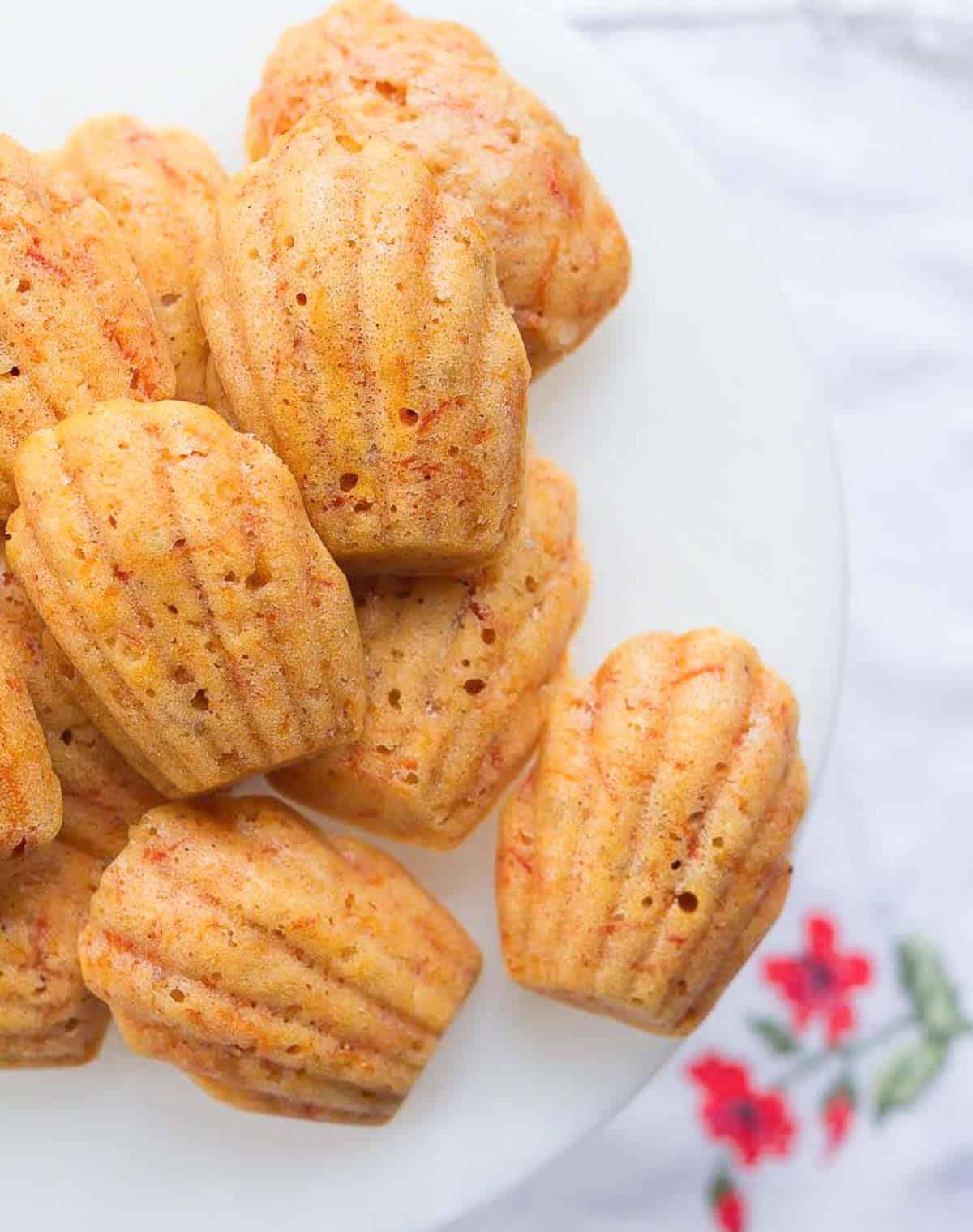Carrot madeleines on a white cake stand.