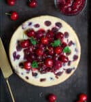cherry cheesecake with cherry sauce and cherries on top.