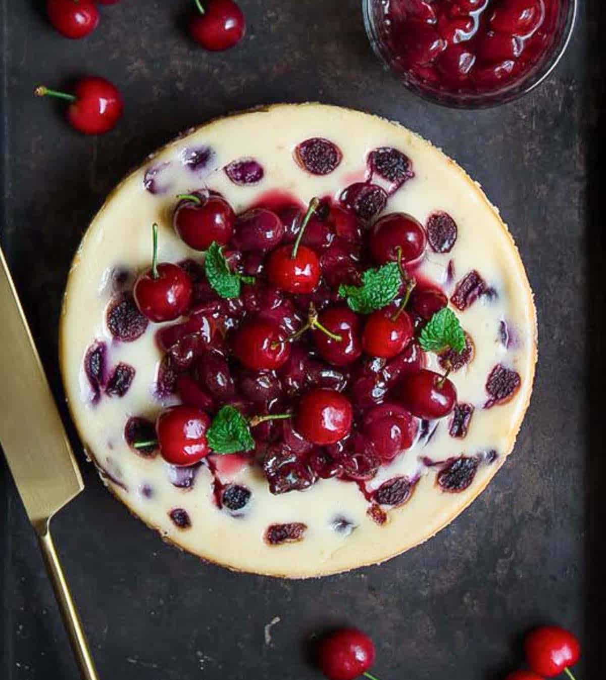 cherry cheesecake with cherry sauce and cherries on top.