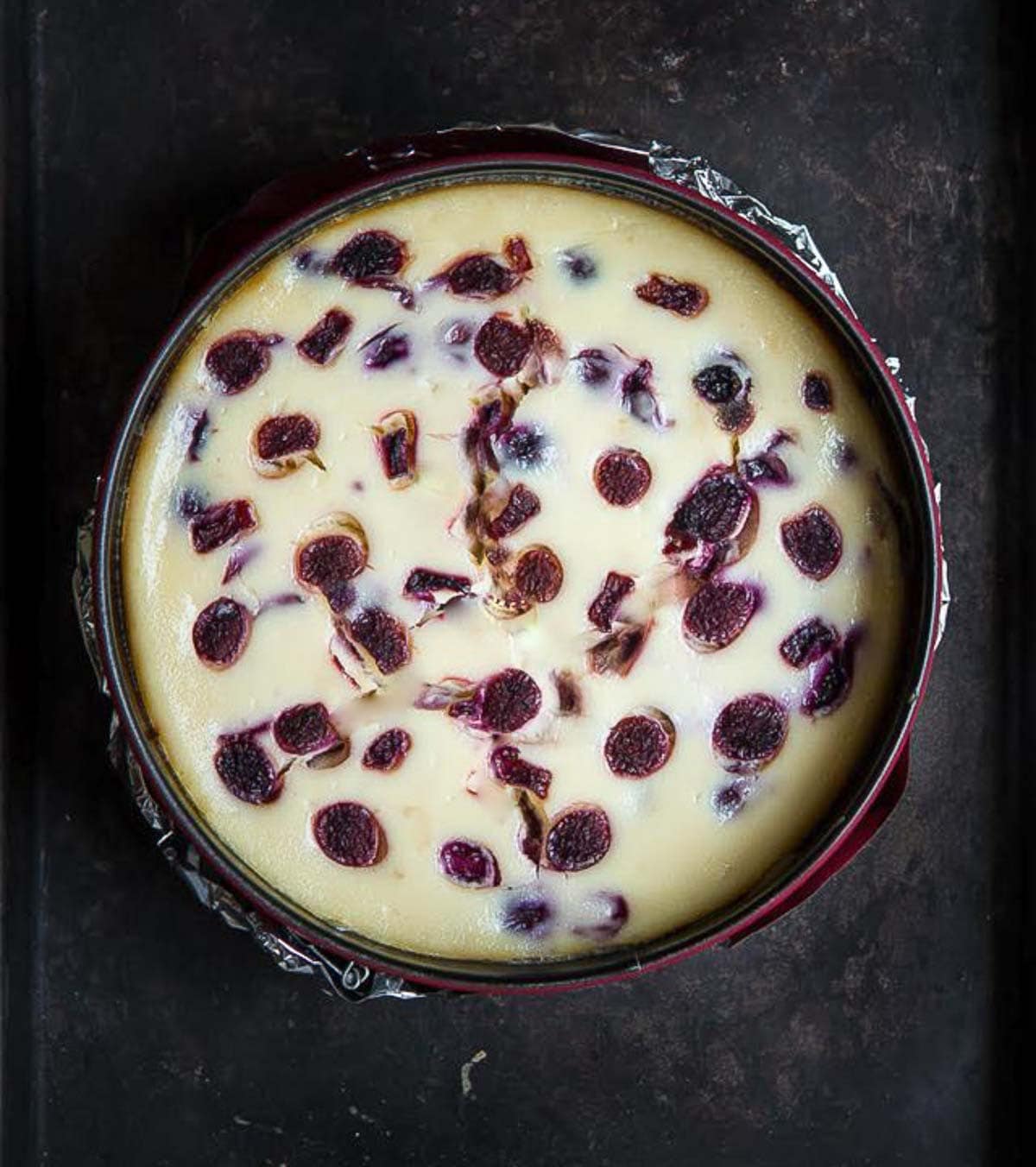 baked cherry cheesecake in a round cake pan.