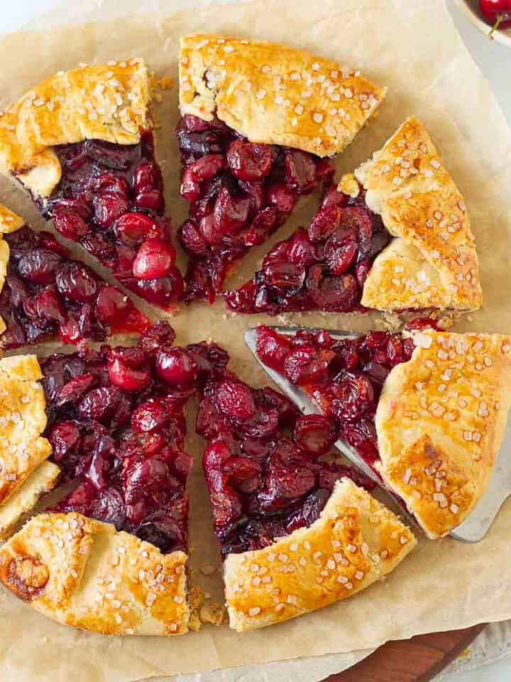 Cherry galette cut into 8 slices with a pie server.