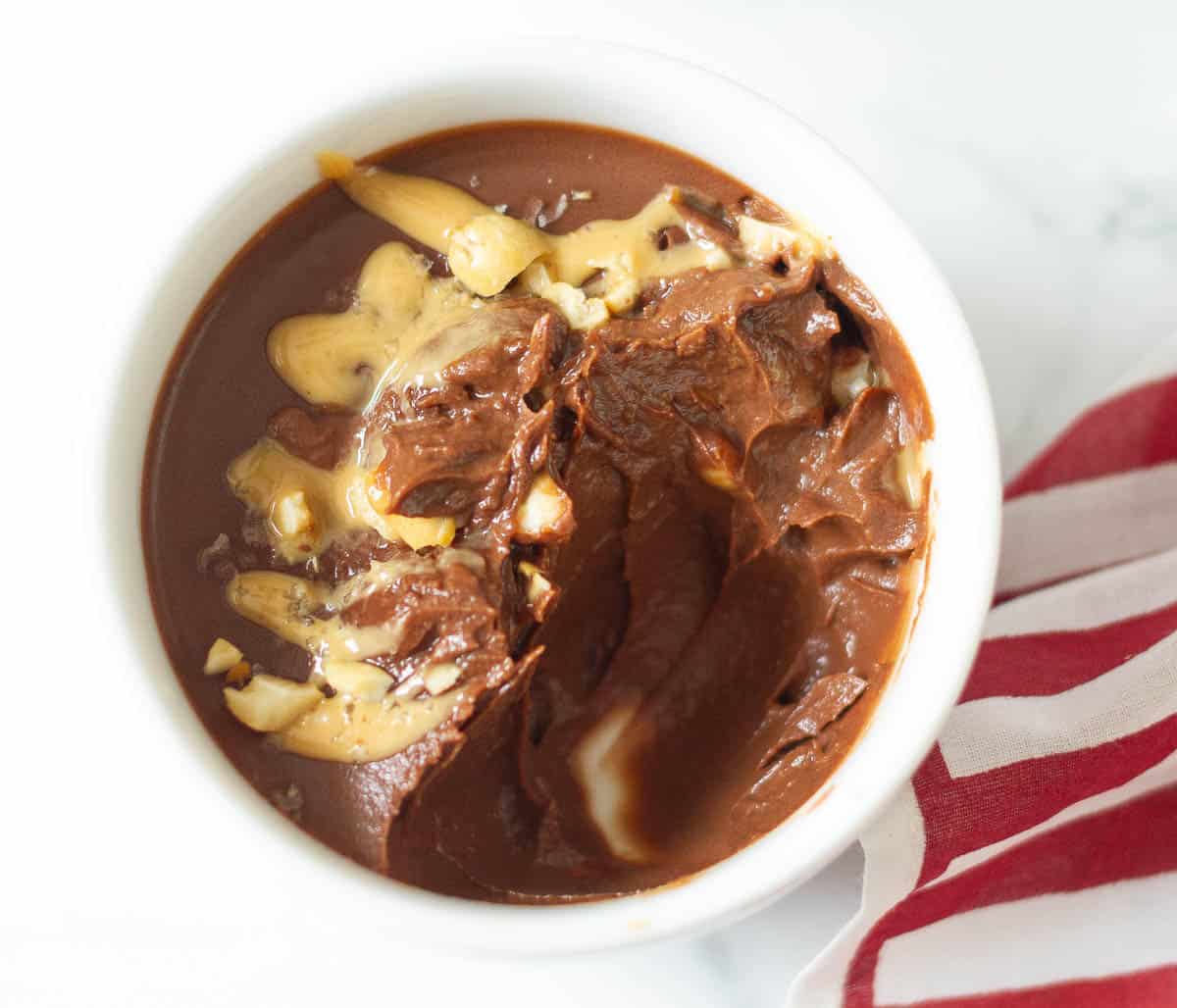 A bowl of pudding with a few spoonfuls taken out.