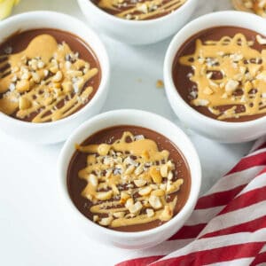 bowls of chocolate pudding with peanut butter drizzled on top.