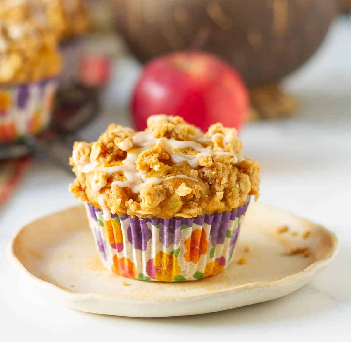 A muffin on a small plate with ingredients around.