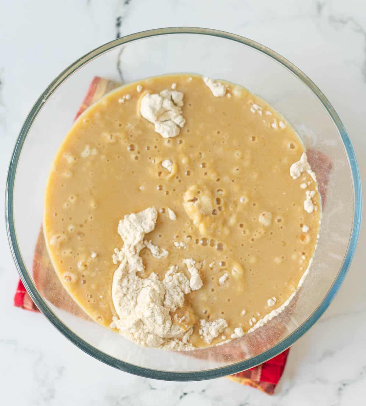 Wet ingredients on top of dry ingredients in a mixing bowl.